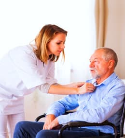 woman helping senior man change clothes