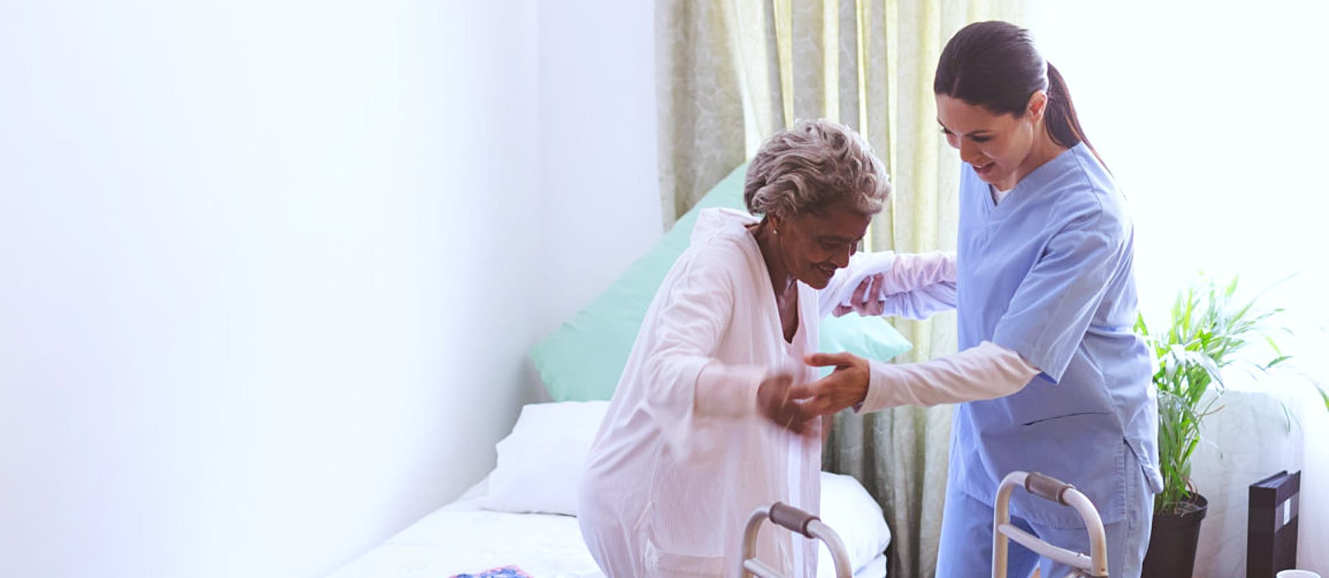 woman helping senior woman stand up