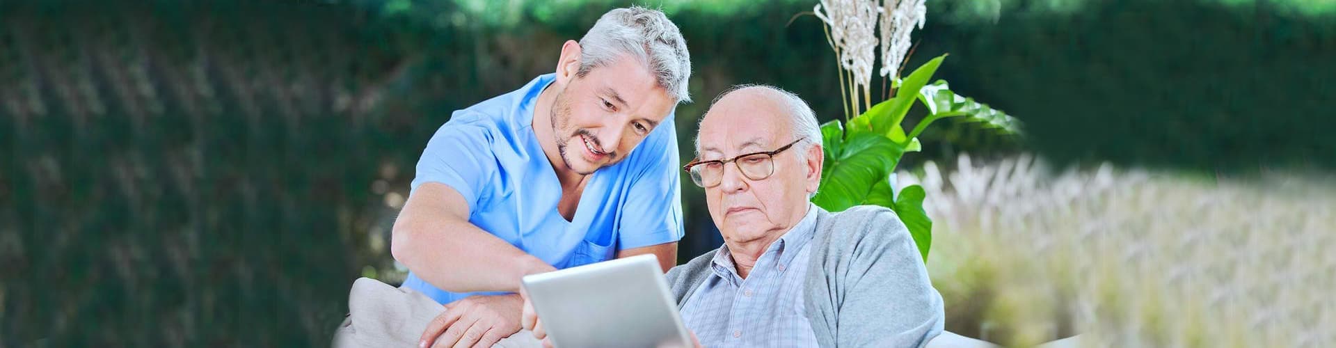 man and senior man looking at the computer